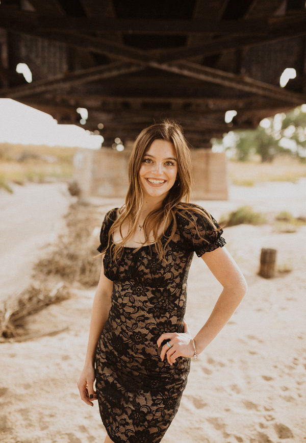 Skyla poses for her senior picture in a sandy, dry river bed beneath bridge spanning on of many flood tributaries of the Big Sandy creek bed.